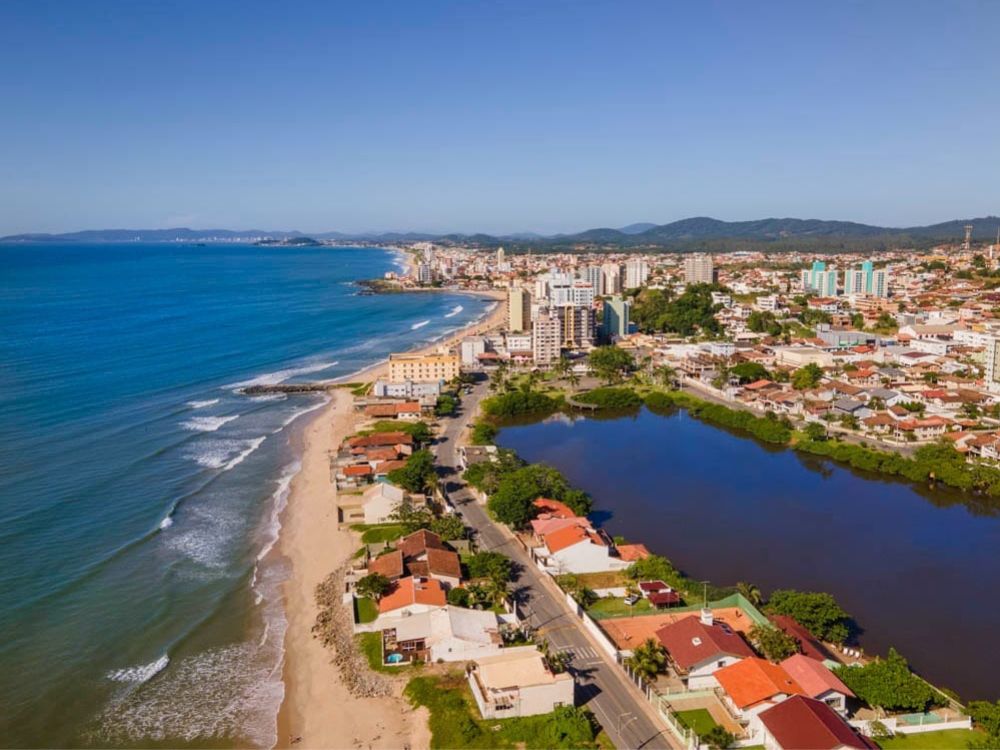 Imagem do centro e da praia de Barra Velha: Vista aérea do centro urbano e da praia, destacando a beleza dos pontos turísticos de Barra Velha SC. Foto: Prefeitura de Barra Velha.