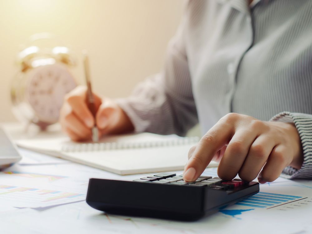 Pessoa fazendo anotações enquanto calcula valores referentes ao ITBI Barra Velha.