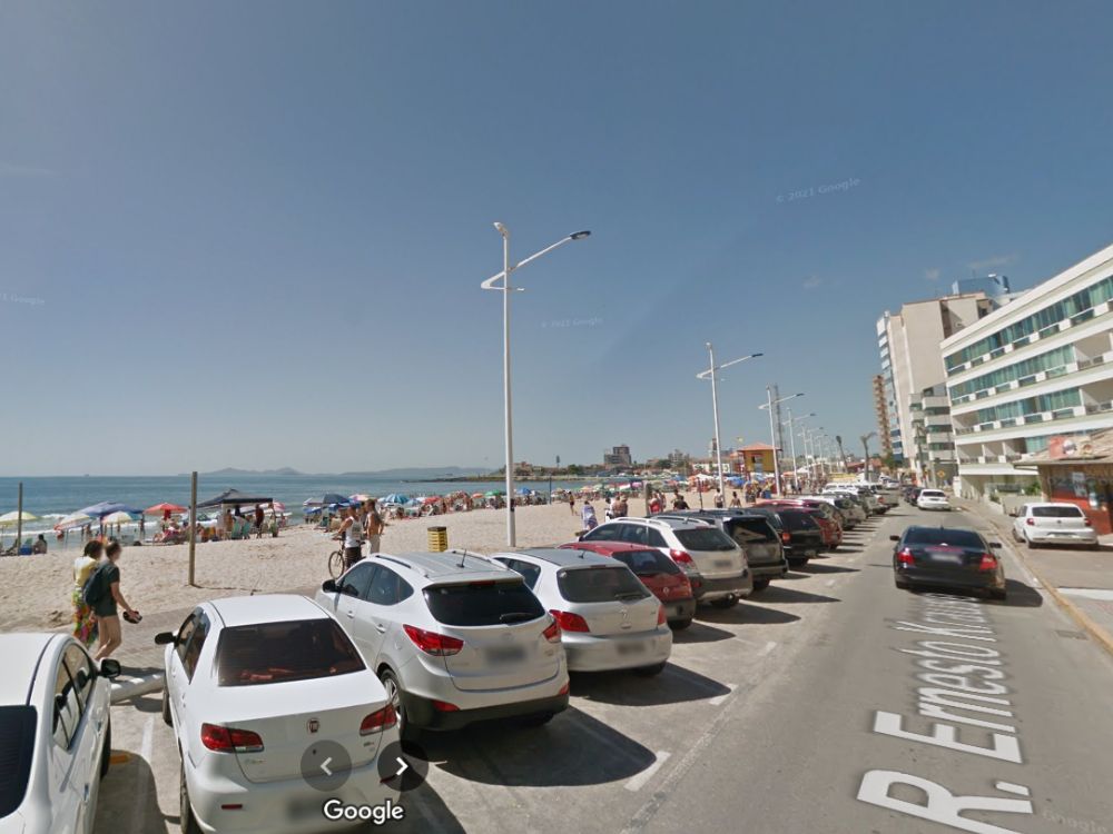 Praia movimentada com prédios e comércio próximo, cenário comum em regiões turísticas com perfil de hotspot imobiliário no litoral catarinense.